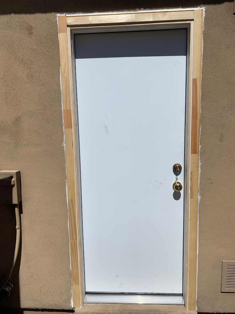 Licensed worker installing a replacement door and frame